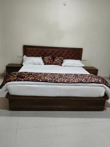 a bed with a wooden headboard in a bedroom at NestIN hotels in Lucknow