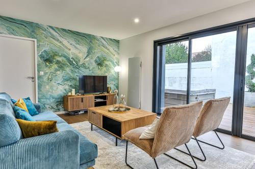 a living room with a couch and a table at Villa Boréal with spa in the heart of St Gilles in Saint-Gilles-Croix-de-Vie