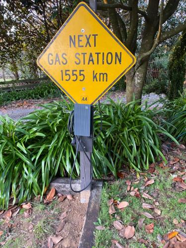 a yellow next gas station sign sitting in the grass at Fig Cottage in New Plymouth