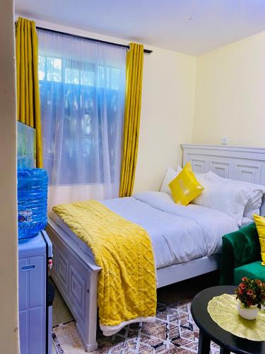 a bedroom with a bed and a window with yellow curtains at The Crown Stay in Machakos