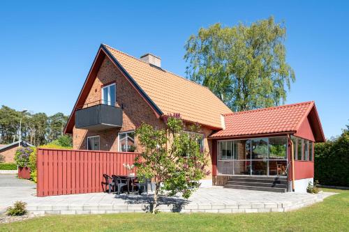 a house with a red fence in front of it at Kärraton Stugor Centrala Åhus in Åhus