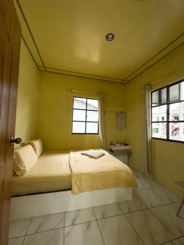 a bedroom with a bed and two windows at Triple A Kundasang in Ranau