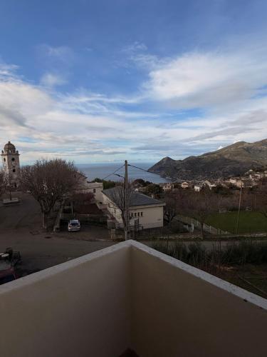 a balcony with a view of a town and a street at Au bon clocher in Canari