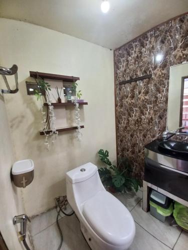 a bathroom with a toilet and a sink at Agora Home in Wonosobo