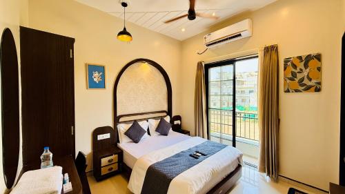 a bedroom with a bed and a large window at Hotel Omkareshwar Jyotirling Inn in Godarpura