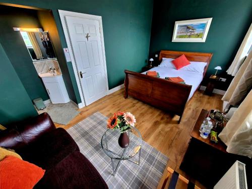 a bedroom with a bed and a table with flowers on it at Cuchulainn Townhouse in Galway