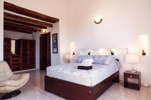 a bedroom with a bed and a chair in it at Casa Bari La Antigua in Barichara