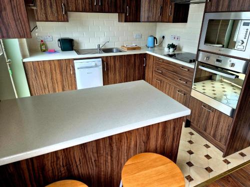 a kitchen with wooden cabinets and a counter top at Cuchulainn Townhouse in Galway