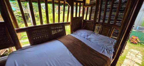 a small bed in a room with a window at RMB's Downton Place in Tagaytay