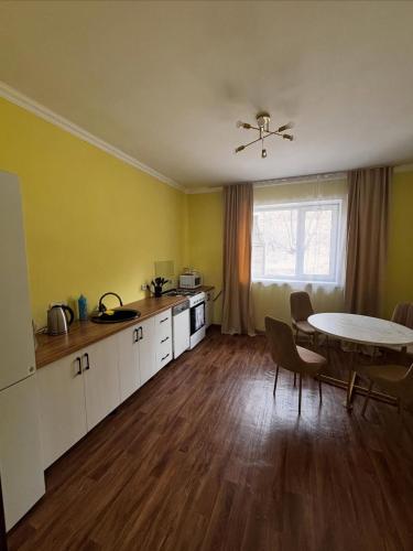 a kitchen with a table and a table and chairs at Дом твоей силы in Talghar