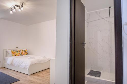 a bedroom with a bed and a glass shower at Deda Studio w. Smart TV · AC · washing machine in Bucharest