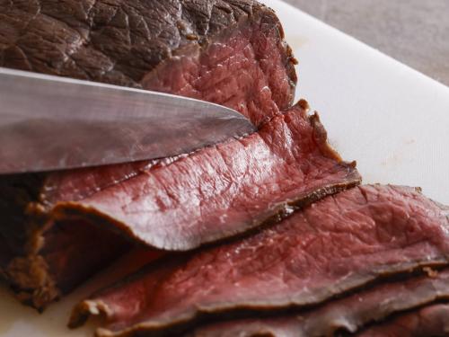 a piece of meat on a plate with a knife at Tateshina Lake Resort in Tateshina