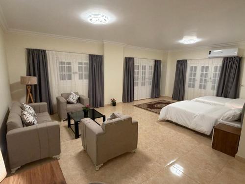 a bedroom with a bed and two chairs and a bed and a couch at 瑞龙居民宿 in New cairo