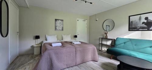 a bedroom with a bed and a blue couch at Glaskogen Holiday Homes in Glava