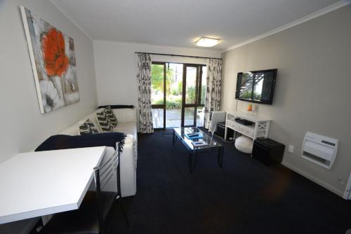 a living room with a couch and a tv at Akaroa Village Inn in Akaroa