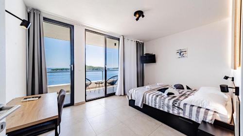a bedroom with a bed and a table with a desk at Villa Evia by Villas Guide in Smokvica