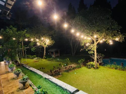 an image of a garden at night with lights at Hotel Kay Terrace in Campaka