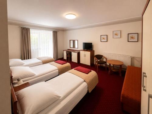a hotel room with four beds and a table at Pensjonat PISZ in Pobierowo
