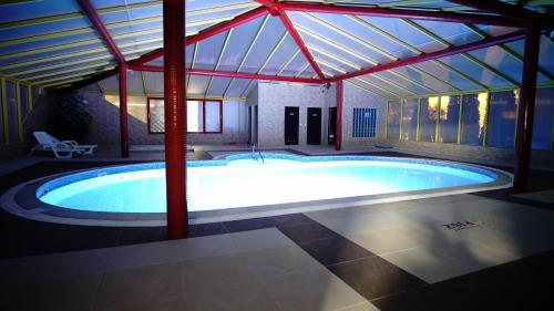 a large swimming pool in a building with a roof at Pensjonat PISZ in Pobierowo