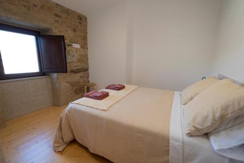 a bedroom with a large bed with a window at Casa Ataraxia II in Boiro