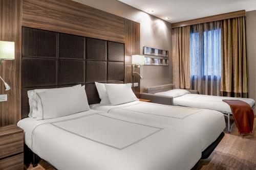 ein Hotelzimmer mit zwei Betten und einem Fenster in der Unterkunft Hotel AC Baqueira Ski Resort, Autograph Collection in Baqueira-Beret