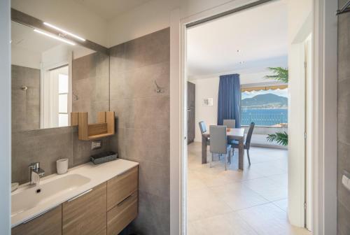 a bathroom with a sink and a dining room at ApartmentsGarda - Villa Giada in Torri del Benaco