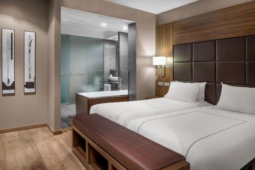 ein Schlafzimmer mit einem großen Bett und ein Badezimmer in der Unterkunft Hotel AC Baqueira Ski Resort, Autograph Collection in Baqueira-Beret