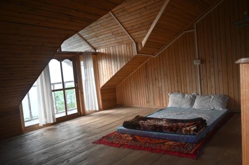 a bedroom with a bed in a wooden room at Denzongpa Homestay in Takdāh