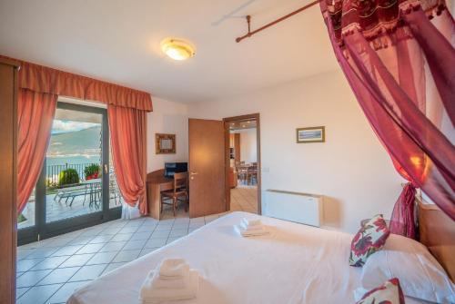 a bedroom with a bed and a view of the ocean at ApartmentsGarda - Villa Giada in Torri del Benaco