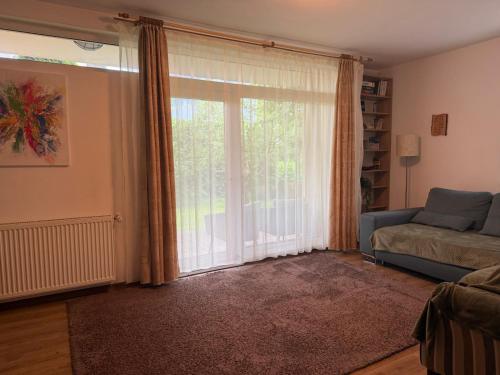 a living room with a large window and a couch at Harmony Haven - Spacious 4BR House with Free Parking in Cluj-Napoca