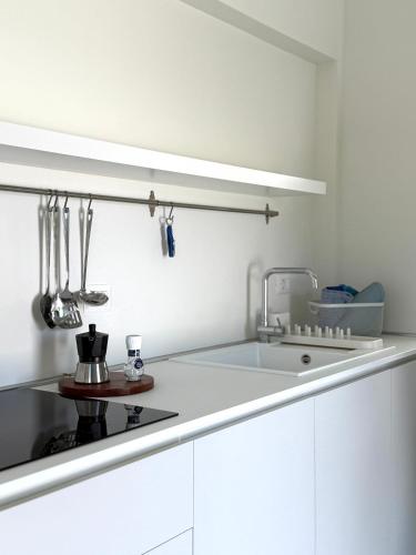 a white kitchen with a sink and a counter at Le villette in Vasto