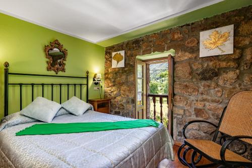 a bedroom with a bed and a stone wall at Casa Engracita in Valle de Lago