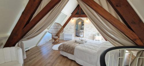 a bedroom with a bed in a attic at La Romantique du Château in Gaillan-en-Médoc