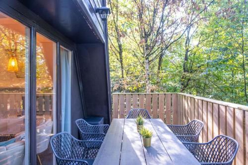 a table and chairs on the back porch of a house at Chalet Lupin in Durbuy