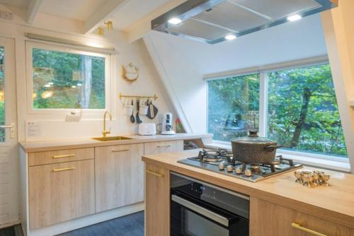 a kitchen with a stove top oven next to a window at Chalet Lupin in Durbuy