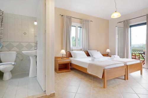 a bedroom with a bed and a toilet and a sink at Villa Rita in Spanokhórion