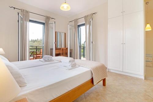 a bedroom with two beds and a balcony at Villa Rita in Spanokhórion