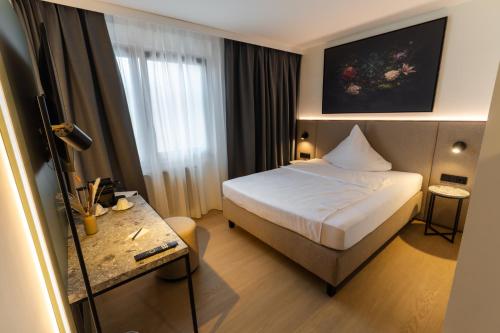 a hotel room with a bed and a table at Hotel Sittardsberg in Duisburg
