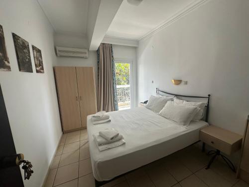 a bedroom with a white bed with towels on it at Apartments Villa Effie in Paralia Katerinis