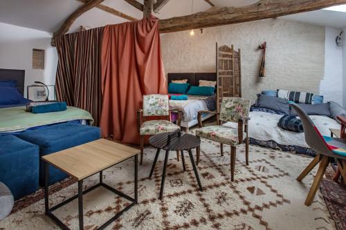 a room with a bed and chairs and a couch at La Grange des zarts in Champagné-le-Sec