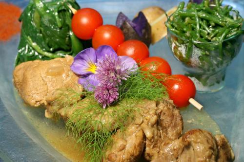 a plate of food with vegetables and flowers on it at Logis Auberge De La Dune - Hôtel & Restaurant in Le Crotoy