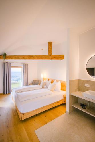 a large white bedroom with a large bed and a sink at Gut Herzogberg in Sonntagberg