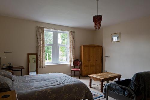 a bedroom with a bed and a table and a window at Monument View in Hexham