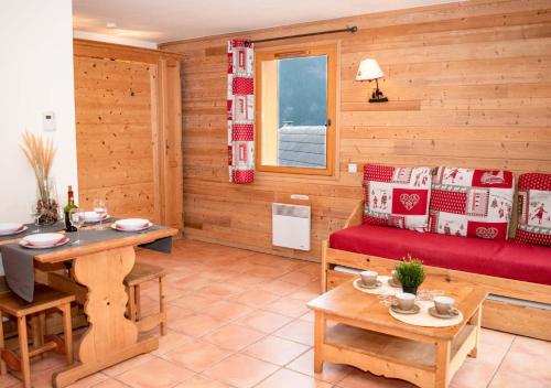 a living room with a red couch and a table at Chalets de Praroustan by Actisource in Pra-Loup