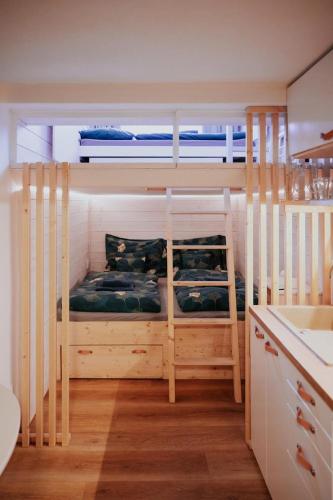 two bunk beds in a room with a kitchen at Apartment Slupečná Lipno in Kramolín
