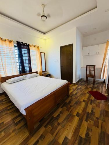 a bedroom with a large bed and a wooden floor at BIG INN Resort in Mattanūr
