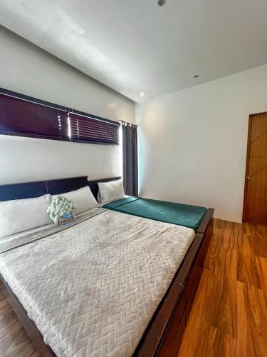 a bedroom with a large bed with a wooden floor at The Hermitage Tagaytay-Junior Suite in Malabag
