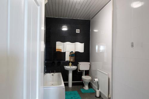 a bathroom with a white toilet and a sink at Monument View in Hexham