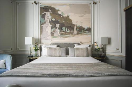 a bedroom with a large bed with a painting on the wall at Hôtel Elysia by Inwood Hotels in Paris