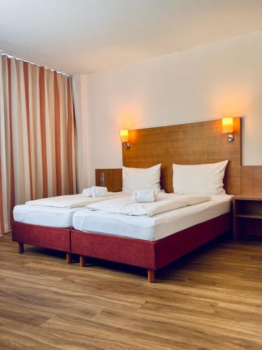 a bedroom with two beds in a room at Bodensee Yachthotel Schattmaier in Kressbronn am Bodensee